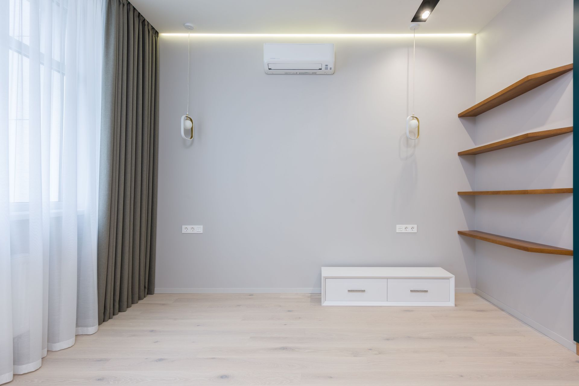 Creative lamps and AC hanging on wall near wooden shelves in modern new apartment with curtains in daylight